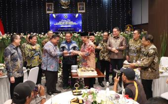 Ketua Bawaslu Rahmat Bagja menerima potongan kue dari Ketua DKPP periode 2012-2017 Jimly Asshiddiqie dalam peluncuran buku Etika yang Melembaga: 70 Tahun Prof. Jimly Asshiddiqie Warisan Gagasan dan Penguatan DKPP, di Jakarta, Jumat (17/4/2026).